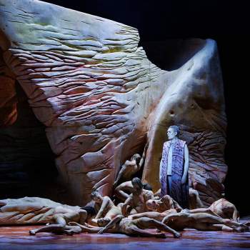 Dansare på scenen med en stor skulptur 