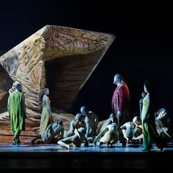 Dansare på scenen med en stor skulptur 