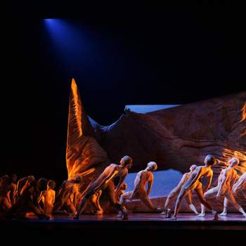 Dansare på scenen med en stor skulptur 